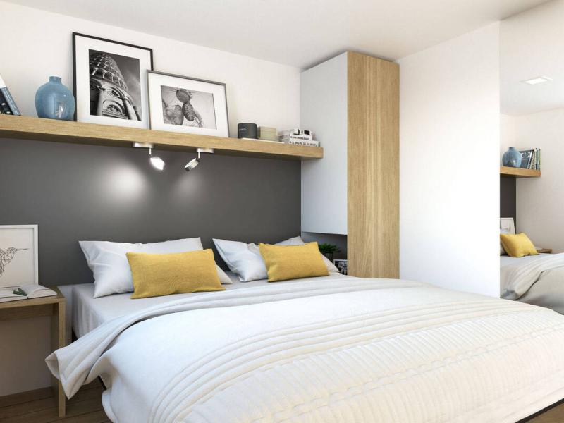 Camera moderna con letto e decorazioni minimaliste, colori neutri e accenti gialli.