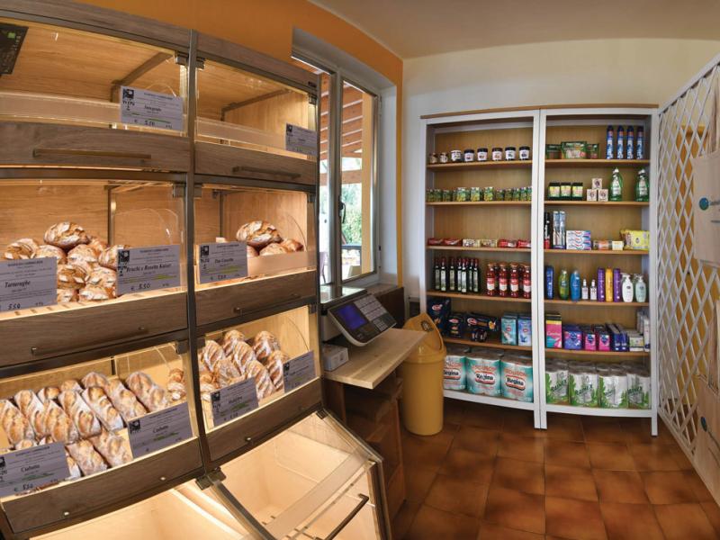 Panetteria con scaffali di prodotti alimentari e articoli per la casa.
